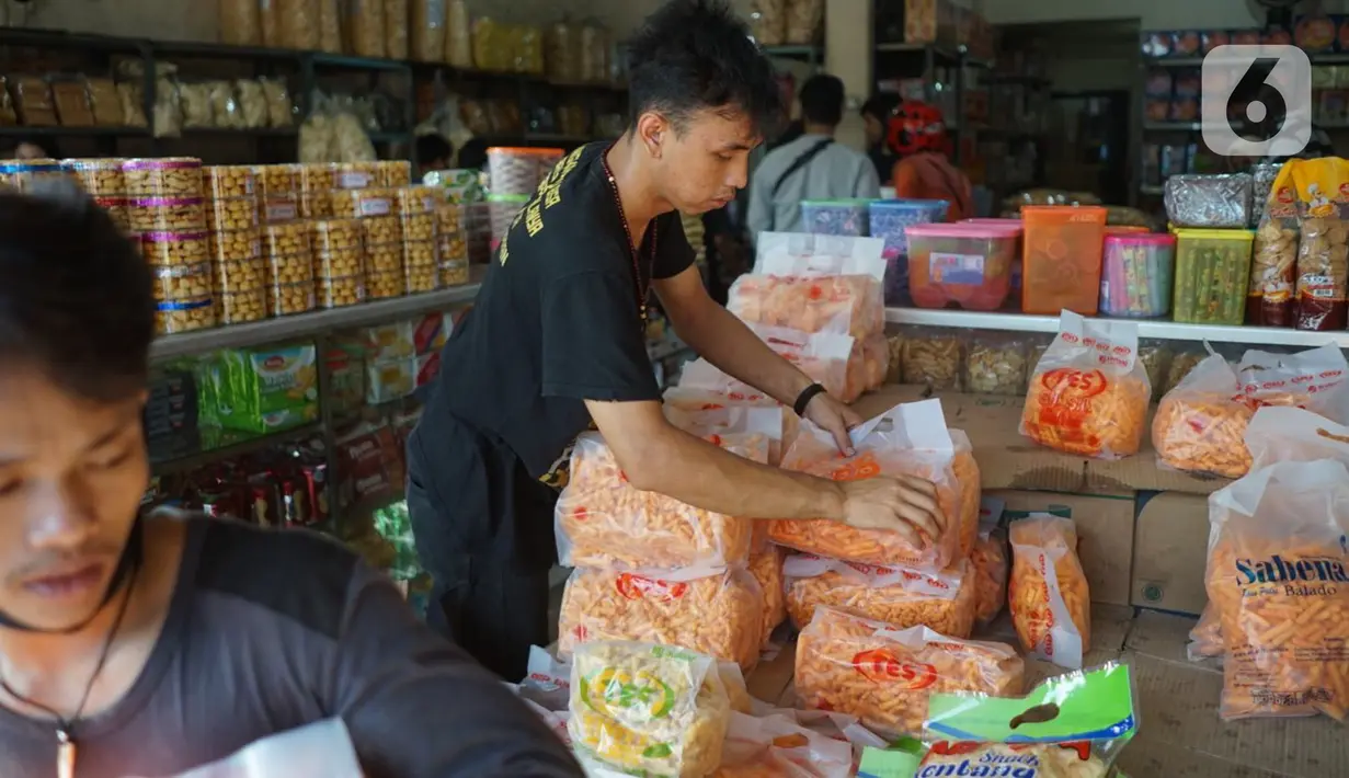 Pekerja menata dagangan kue kering di salah satu toko penjualan kue kering di kawasan Ciracas, Jakarta, Selasa (19/5/2020). Adanya pandemi covid-19 diakui para pedagang menyebabkan penjualan kue kering menjelang lebaran turun hingga 50 persen. (Liputan6.com/Immanuel Antonius)