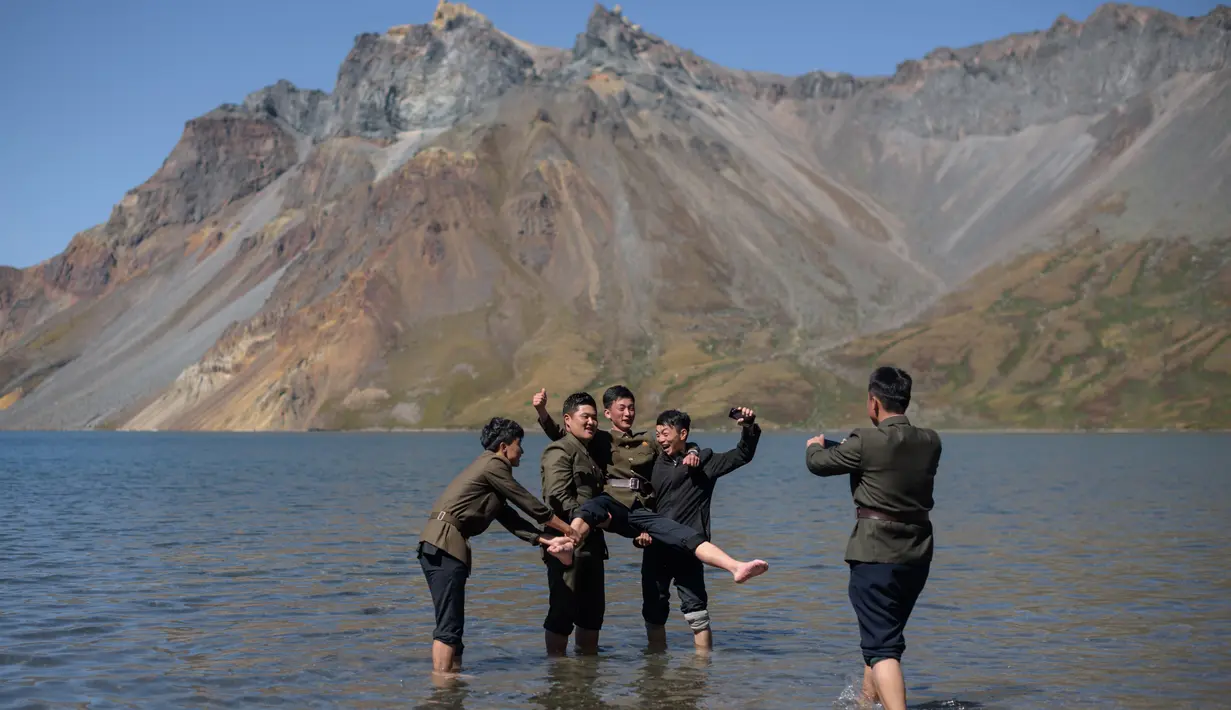 Gambar pada 11 September 2019 memperlihatkan siswa Korea Utara berpose di danau Chonji atau 'Heaven lake' saat mengunjungi kawasan Gunung Paektu di Samjiyon. 'Heaven lake' atau Danau surga ini ada di ketinggian 2.190 mdpl dan punya kedalaman 384 meter. (Photo by Ed JONES / AFP)