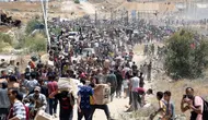Orang-orang membawa kotak-kotak berisi pasokan bantuan dari Gaza Humanitarian Foundation (GHF), sebuah kelompok bantuan swasta yang didukung oleh Amerika Serikat (AS) yang telah melewati sistem yang telah lama dipimpin oleh PBB di wilayah tersebut, dari pusat distribusi bantuan di Jalur Gaza tengah pada 29 Mei 2025. (Eyad BABA/AFP)