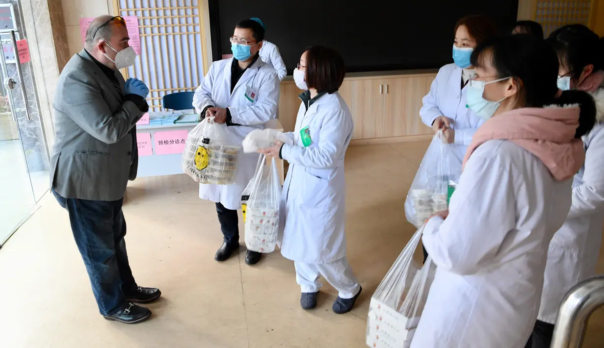 Alaaddin Colak mengucapkan terima kasih kepada para pekerja medis saat membawakan makanan gratis buatan restorannya di Fuzhou, China, 9 Februari 2020. Makanan gratis bagi petugas pencegahan epidemi Corona itu disediakan guna menunjukkan dukungan serta memberikan semangat. (Xinhua/Jiang Kehong)
