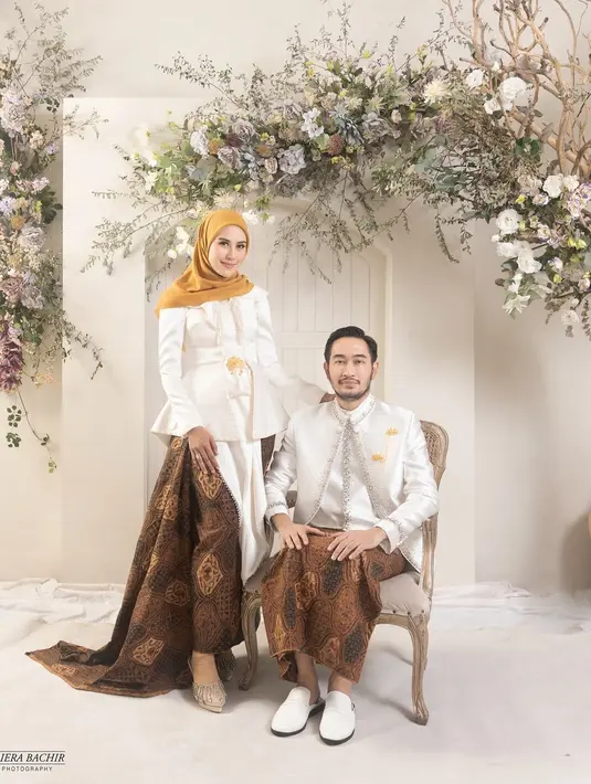 Syahnaz Sadiqah melakoni pemotretan keluarga bersama sang suami Jeje dan buah hati mereka dengan mengenakan busana tradisional berupa kebaya dan beskap serba putih. Penampilan Syahnaz pun dilengkapi kain batik coklat sebagai bawahan dan kerudung kuning. [@dierabachir].