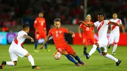 Penyerang Chile, Eduardo Vargas (tengah) berusaha melewati dua pemain Peru pada Kualifikasi Piala Dunia 2018 di National Stadium, Santiago, Chile (11/10).  Chile menang atas Peru dengan skor 2-1. (REUTERS/Ivan Alvarado)