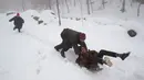 Anak-anak bermain kereta luncur di lereng yang tertutup salju di Srinagar, kawasan Kashmir yang dikuasai India, Sabtu (5/1). Wilayah Kashmir mengalami salju selama beberapa hari yang mengakibatkan terputus jalan raya Jammu-Srinagar (AP Photo/Dar Yasin)