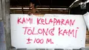Warga bediri di posko dengan pesan bertuliskan Kami Kelaparan Tolong Kami pasca gempa bumi dan tsunami di Jalan Trans Sulawesi, Palu, Sulawesi Tengah, Kamis (4/10). (Liputan6.com/Fery Pradolo)