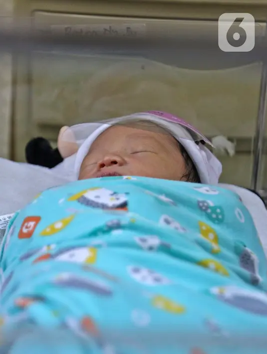 Seorang bayi memakai face shield atau pelindung wajah di Rumah Sakit Ibu dan Anak Tambak, Jakarta, Selasa (14/4/2020). RSIA Tambak sejak 12 April 2020 membuat kebijakan bayi yang baru lahir dipakaikan pelindung wajah untuk mencegah terpapar virus corona COVID-19. (Liputan6.com/Herman Zakharia)