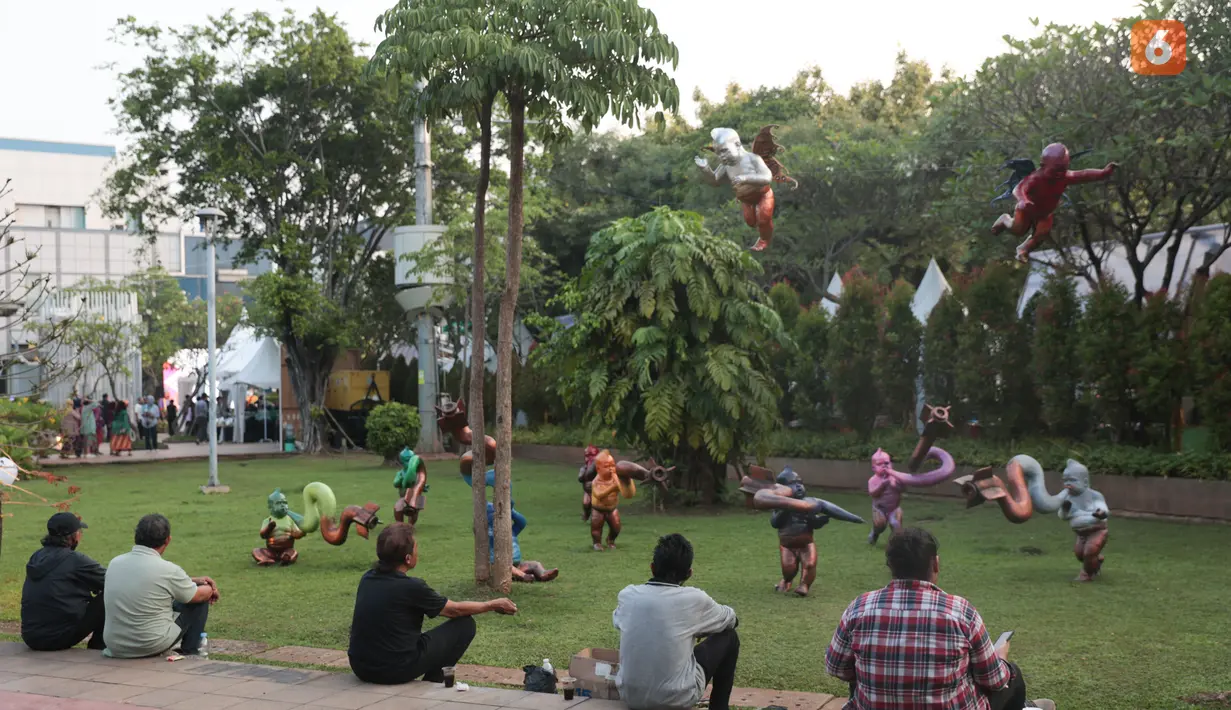 Pengunjung mengamati karya dalam pameran seni rupa kontemporer luar ruang Jakarta Provoke! di Taman Menteng, Jakarta Pusat, Jumat (17/7/2026). Pameran gratis yang berlangsung hingga 26 Juli 2026 ini menghadirkan 25 karya dari 25 seniman dan kolektif tentang dinamika kehidupan Jakarta. (KLY/Budy Santoso)