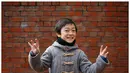 Natsuki Ariga (9 Th), berpose usai menggambar tentang hadiah apa yang dia ingin saat Natal dari Santa di Tokyo, Jepang 1 Desember 2016. Natsuki ingin mendapatkan buku komik di Jepang dan sejarah dunia. (REUTERS / Toru Hanai)