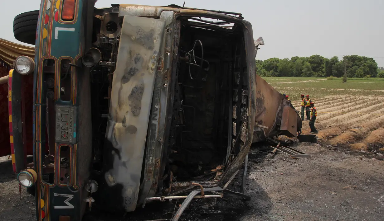 Bangkai truk tangki minyak yang hangus terbakar usai terbalik dan meledak di jalan raya dekat Bahawalpur, Pakistan (25/6). Dikabarkan, sedikitnya 123 orang tewas dan 100 lainnya mengalami luka-luka. (AFP Photo/SS Mirza)