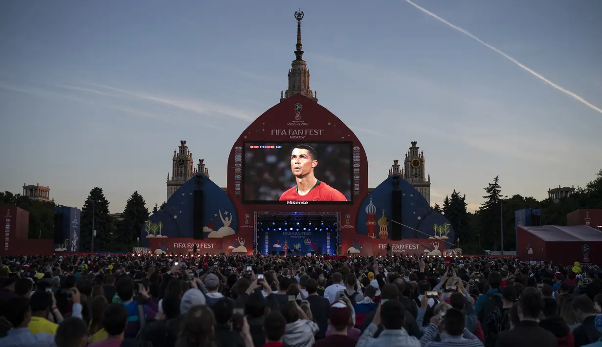 Bintang Portugal, Cristiano Ronaldo, saat melawan Spanyol tersorot pada layar raksasa di Moskow, Jumat (15/6/2018). CR 7 pencetak hattrick perdana Piala Dunia 2018. (AP/Felipe Dana)