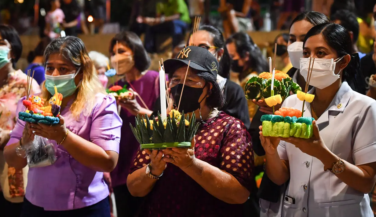 Orang-orang bersiap melepaskan lentera mengambang ke sungai selama festival Loy Krathong di provinsi Narathiwat, Thailand selatan (8/11/2022). Festival ini biasanya berlangsung pada akhir musim hujan ketika bulan purnama menyala di langit pada November. (AFP/Madaree Tohlala)