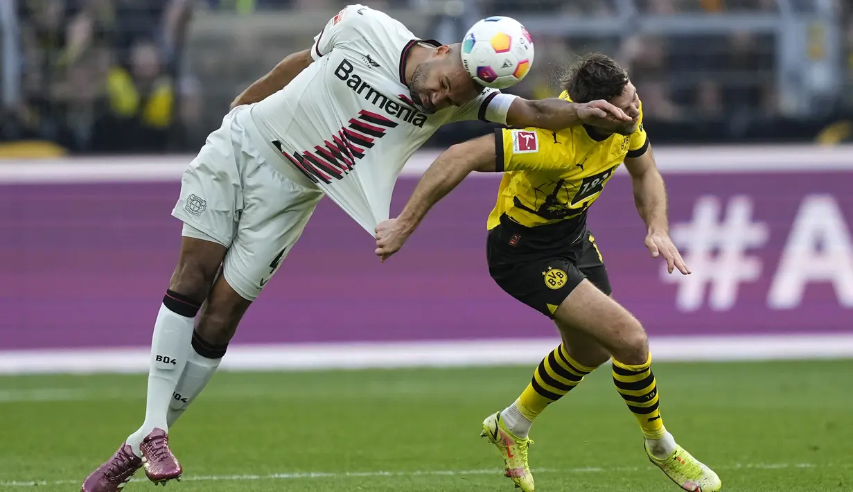 Bek Bayer Leverkusen Jonathan Tah berebut bola dengan penyerang Borussia Dortmund Niclas Fuellkrug dalam laga lanjutan pekan ke-30 Bundesliga 2023/24 di Signal-Iduna Park, Minggu (21/4) malam WIB. (AP Photo/Martin Meissner)