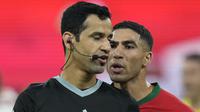 Achraf Hakimi tampak menjadi pemain Maroko yang paling kecewa dengan Abdulrahman Al Jassim (kiri). Bek asal Paris Saint-Germain itu terus melemparkan kata-kata kepada pengadil lapangan asal Qatar. (AP Photo/Francisco Seco)