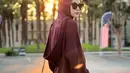 Seperti potret ini, berpose dengan latar matahari terbenam, Zaskia tampil casual chic mengenakan long sleeve top maroon dipadukan dengan hijab warna senada dan cargo pants warna krem. (Instagram/zaskiadyamecca).
