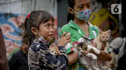 Warga mengantre membawa hewan peliharaannya untuk diperiksa kesehatannya di Kawasan Tebet, Jakarta, Senin (22/2/2021). Dinas KPKP Provinsi DKI Jakarta mengadakan pemeriksaan kesehatan hewan peliharaan secara gratis bagi yang terdampak banjir. (Liputan6.com/Faizal Fanani)