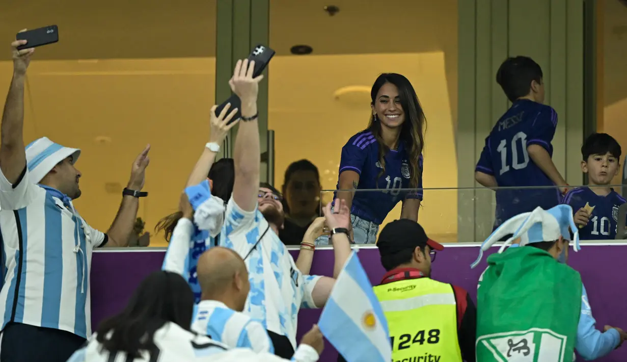 Istri penyerang Argentina Lionel Messi, Antonela Roccuzzo, menyapa suporter jelang laga semifinal Piala Dunia Qatar 2022 antara Argentina dan Kroasia di Lusail Stadium di Lusail, Doha, Rabu (14/12/2022). Argentina menang atas Kroasia 3-0. (AFP/Juan Mabromata)