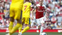 Aksi gelandang Arsenal, Mesut Ozil pada laga lanjutan Premier League yang berlangsung di Stadion Emirates, Minggu (21/4). Arsenal kalah 2-3 kontra Crystal Palace. (AFP/Adrian Dennis)