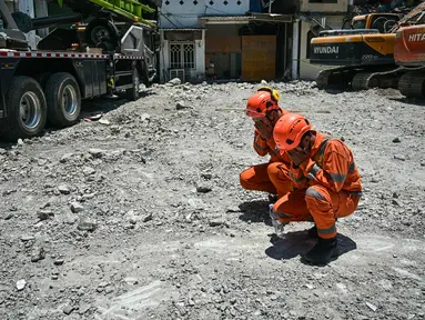 Personel dari tim dari Badan Nasional Pencarian dan Pertolongan (BASARNAS) berdoa setelah prosesi penutupan yang menandai berakhirnya operasi pencarian dan penyelamatan korban runtuhnya bangunan musala di Pondok Pesantren Al Khoziny di Sidoarjo, Jawa Timur, pada 7 Oktober 2025. (JUNI KRISWANTO/AFP)