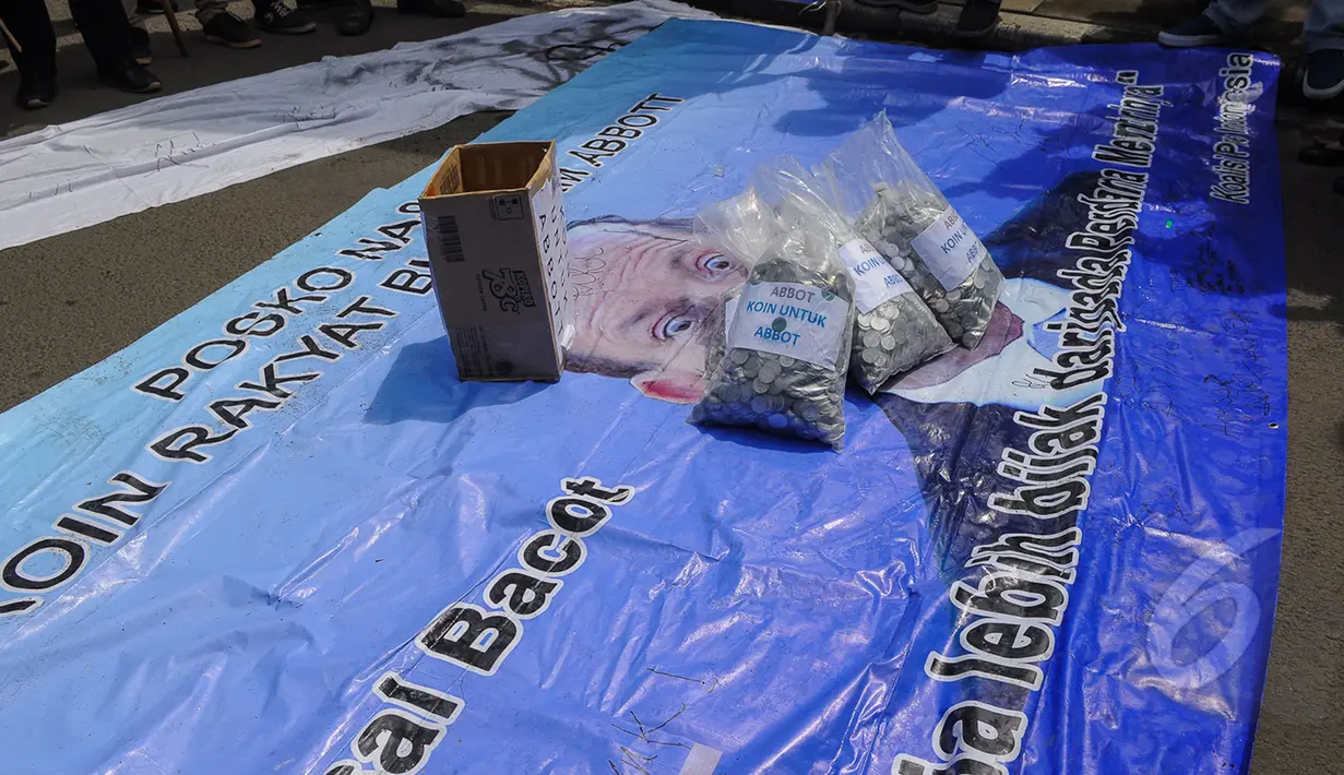 Ribuan koin diletakkan di atas poster bergambar PM Tony Abbott di depan Gedung Kedubes Australia, Jakarta, Selasa (10/3/2015). Koin tersebut bentuk protes atas pernyataan PM Australia Tony Abbott. (Liputan6.com/Faizal Fanani) 