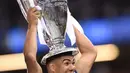 Gelandang Real Madrid Casemiro mengangkat trofi usai memenangkan pertandingan Liga Champions di Stadion Cardiff, Wales (3/6). Dalam pertandingan tersebut Casemiro berhasil mencetak satu gol ke gawang Juventus. (AFP Photo/Filippo Monteforte)