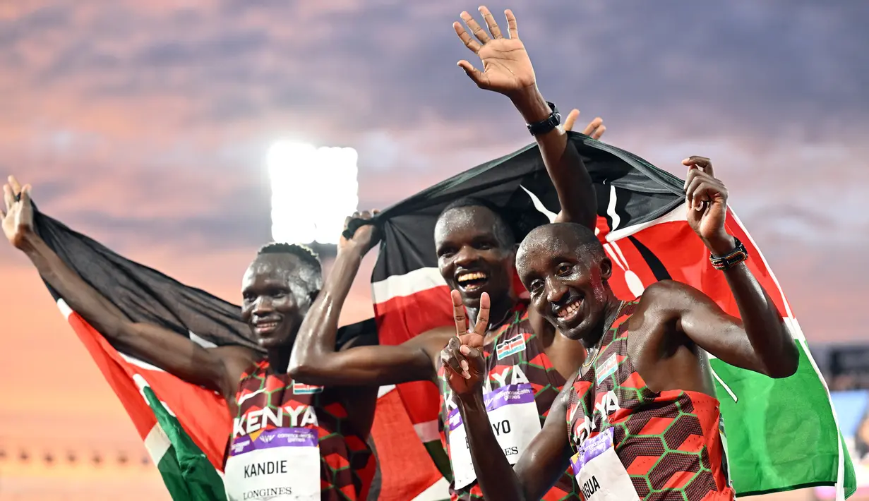 Peraih medali perak Daniel Simiu Ebenyo (tengah), peraih medali perunggu Kibiwott Kandie (kiri), dan Edward Zakayo Pingua dari Kenya melakukan selebrasi usai final atletik 10.000 meter putra pada hari kelima Commonwealth Games di Alexander Stadium, di Birmingham, Inggris pada 2 Agustus 2022. (AFP/Glyn Kirk)
