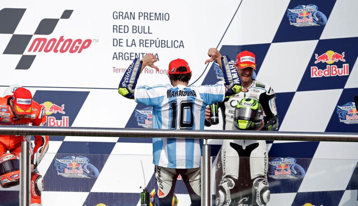 Saat menaiki podium juara, Valentino Rossi memakai jersey timnas Argentina dengan nama Diego Maradona yang merupakan legenda tim Tango. (AP Photo/Natacha Pisarenko)