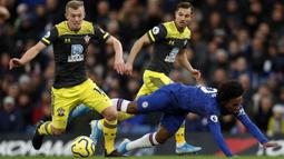 Gelandang Chelsea, Willian, terjatuh saat berusaha melewati pemain Southampton pada laga Premier League 2019 di Stadion Stamford Bridge, Kamis (26/12). Chelsea menyerah 0-2 dari Southampton. (AFP/Adrian Dennis)