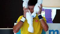 Petenis Serbia, Novak Djokovic, merasa kepanasan saat menghadapi petenis Korsel, Hyeon Chung, pada ajang Australia Terbuka 2016 di Melbourne, Senin (18/1/2016).