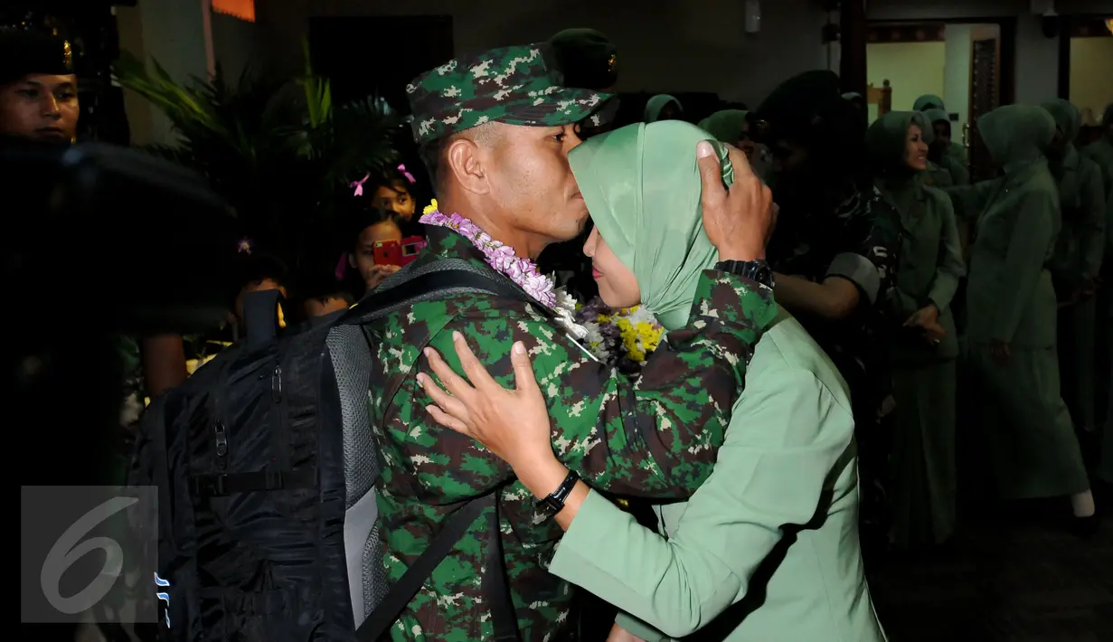 Personel TNI AD yang tergabung dalam kontingen AASAM mencium kening pasangannya saat penyambutan kedatangan di Bandara Soetta, Banten, Senin (23/5/2016). TNI AD menjadi juara umum AASAM 2016 yang digelar di Australia. (Liputan6.com/Helmi Fithriansyah)