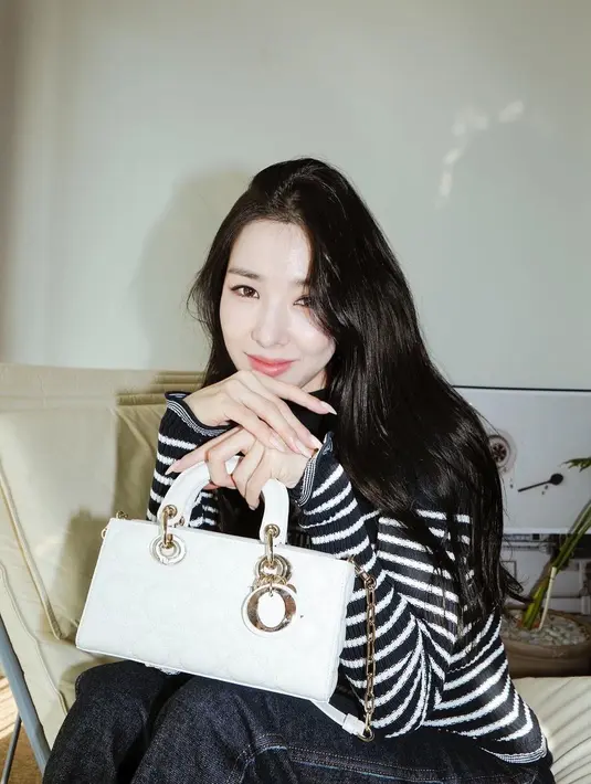 Tiffany Young tampil kasual mengenakan long sleeved sweater Dior dipadu tas Dior Small Lady D-Joy warna putih. [Dior].