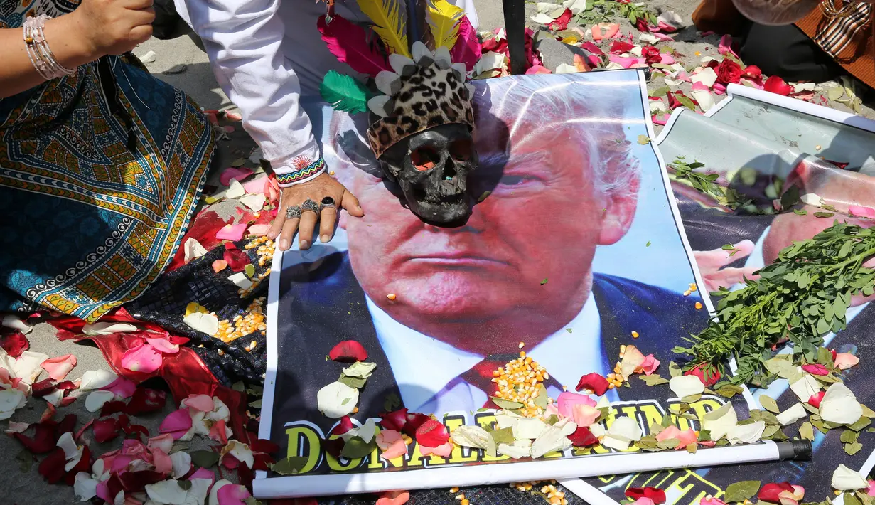Kepala tengkorak diletakkan di atas poster bergambar Capres AS dari Partai Republik, Donald Trump, saat dukun Peru melakukan ritual prediksi menjelang pemilihan presiden AS, di Lima, Peru, Senin (7/11). (REUTERS/Mariana Bazo)