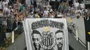 Pendukung Santos membentangkan banner bergambar legenda Brasil, Pele dan Neymar saat pengenalan pemain baru Santos, Neymar di Vila Belmiro, Sao Paulo, Brasil, Sabtu (01/02/2025) WIB. (AFP/Nelson Almeida)