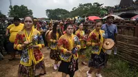 Orang-orang memainkan alat musik saat mereka mengambil banteng untuk parade selama kompetisi balap banteng Karapan Sapi di Bangkalan, pulau Madura, Jawa Timur, Minggu (16/10/2022). Lomba karapan sapi yang memperebutkan Piala Presiden itu diikuti 24 pasang sapi dari sejumlah daerah di Madura. (Juni Kriswanto/AFP)