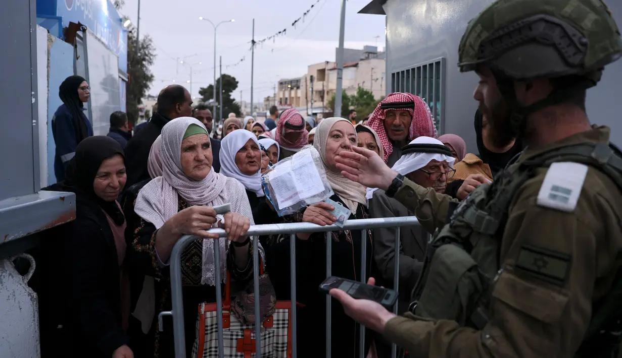 Warga Palestina menunggu izin untuk menyeberang di sebuah pos pemeriksaan Israel di Betlehem, di Tepi Barat pada 29 Maret 2024. (HAZEM BADER/AFP)