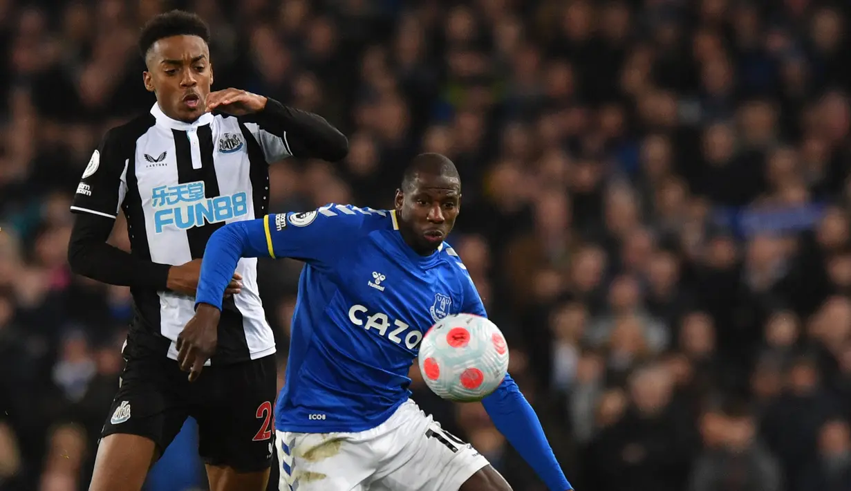 Gelandang Newcastle United Joe Willock (kiri) berebut bola dengan gelandang Everton Abdoulaye Doucoure pada lanjutan Liga Inggris di Stadion Goodison Park, Liverpool, Jumat (18/3/2022) dini hari WIB. Bertindak sebagai tuan rumah, Everton menang tipis 1-0.  (Anthony Devlin / AFP)