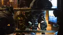 Polisi memeriksa sebuah halte bus yang rusak akibat terkena ledakan di Moskow, Rusia, Senin (7/12). Tiga orang luka terkena pecahan kaca. Bahan peledak diperkirakan dilemparkan dari mobil atau bangunan perumahan di dekatnya. (AFP/NATALIA Kolesnikova)