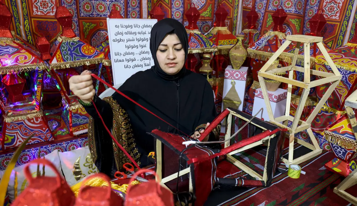 Reham Shurab, salah satu perajin Palestina menyelesaikan pembuatan lentera tradisional "fanous" untuk dekorasi menjelang bulan suci Ramadan, di bengkel rumahnya di Khan Yunis di Jalur Gaza Selatan pada Senin 13 Maret 2023. Lentera tradisional "fanous" hanya muncul saat bulan Ramadan, sehingga keberadaan lentera warna-warni itu dikenal pula dengan sebutan fanous Ramadan. (SAID KHATIB/AFP)