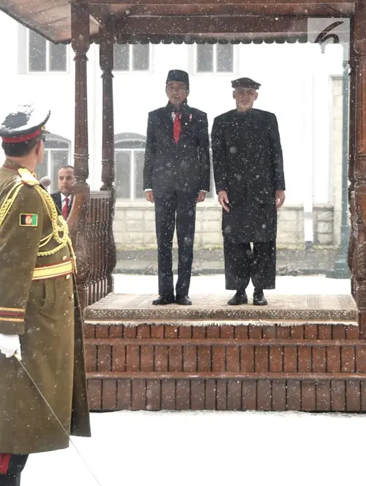 Presiden Afghanistan Ashraf Ghani menyambut kedatangan Presiden RI Joko Widodo (Jokowi) di tengah hujan salju, dalam kunjungan kenegaraan di Istana Presiden Arg, Kabul, Senin (29/1). (Liputan6.com/Pool/Biro Pers Setpres)