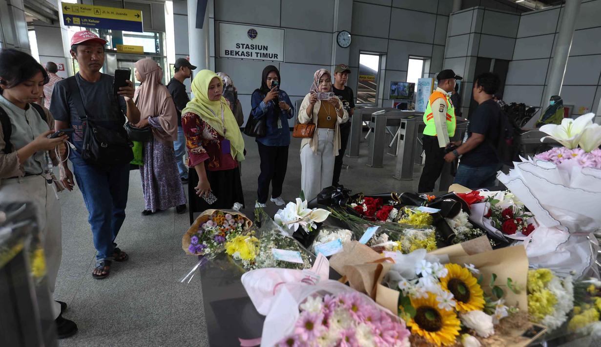 Karangan bunga tersebut menjadi simbol duka atas 16 korban meninggal dunia dalam insiden tabrakan antara kereta api Argo Bromo Anggrek dan KRL Commuter Line di Stasiun Bekasi Timur. Tampak dalam foto, warga menyaksikan karangan bunga di dekat pintu masuk peron Stasiun Bekasi Timur, Bekasi, Jawa Barat, Kamis (30/4/2026). (Kapanlagi.com/Budy Santoso)