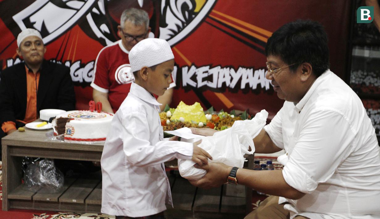Direktur Utama Persija Jakarta, Gede Widiade, memberikan santunan kepada anak yatim saat acara syukuran di Kantor Persija, Jakarta. Acara ini merupakan peringatan hari jadi Persija ke-90. (Bola.com/Yoppy Renato)