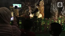 Pengunjung menyaksikan replika hewan prasejarah dalam wahana Dino Factory by Dino Island di Mal Kota Kasablanka, Jakarta, Jumat (17/12/2021). Wahana dihardikan untuk memeriahkan Natal 2021 dan tahun baru 2022. (Liputan6.com/Herman Zakharia)