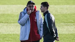 Pelatih Juventus Maurizio Sarri (kiri) berbicara dengan penyerang Cristiano Ronaldo selama sesi latihan di Continassa Training Ground di Turin (25/11/2019). Sebelumnya hubungan Ronaldo dan Sarri dikabarkan renggang akibat Ronaldo ditarik keluar saat melawan AC Milan. (AFP/Marco Bertorello)