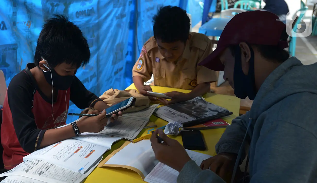Para siswa belajar online di Tenda Wifi gratis di taman warga RT 013, Jakarta Timur, Rabu (12/8/2020). Tenda belajar tersebut menyediakan fasilitas wifi gratis bagi anak-anak sekolah yang terkendala dengan mahalnya kuota internet. (merdeka.com/Imam Buhori)