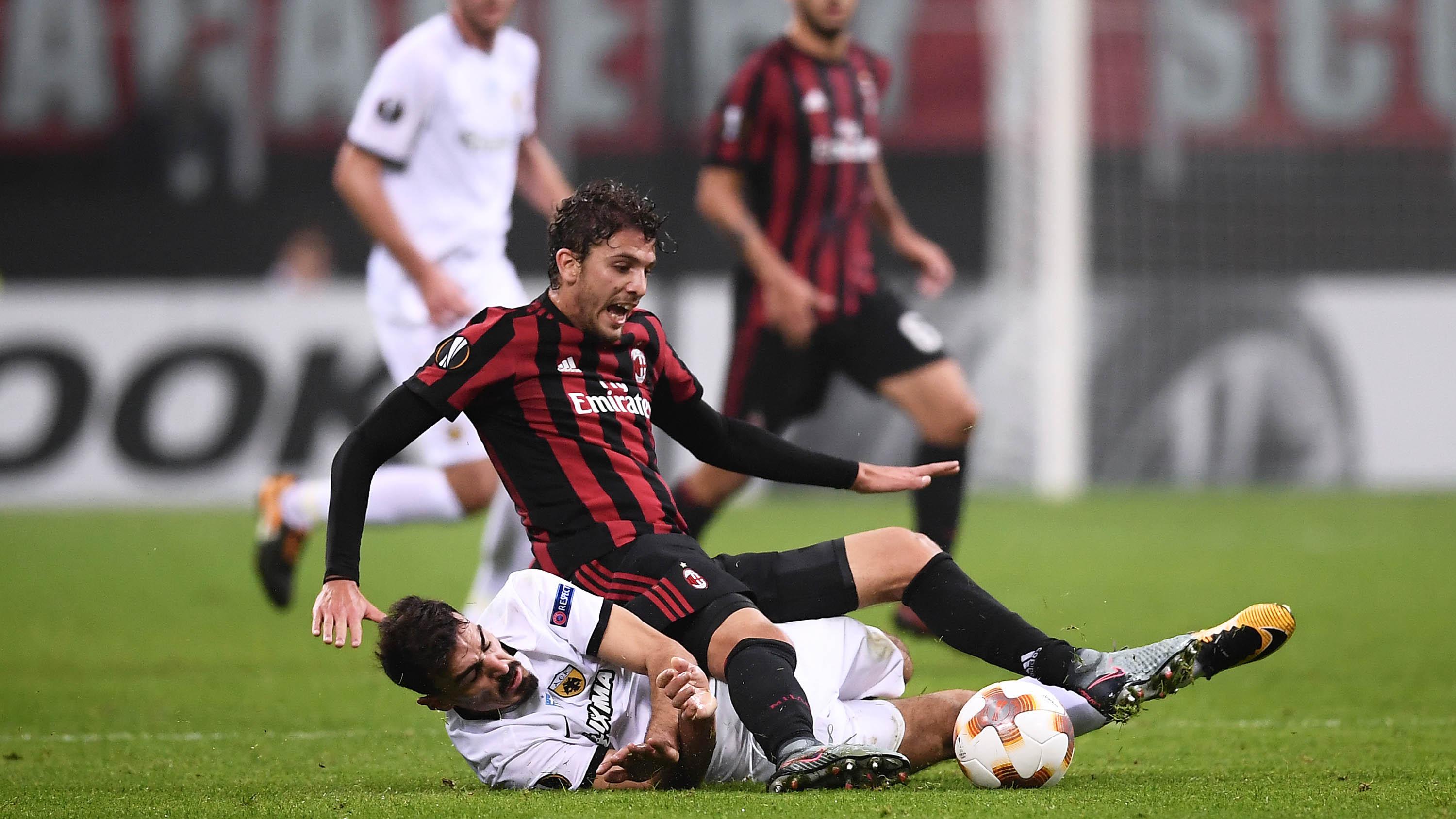 Penggawa AC Milan, Manuel Locatelli, berebut bola dengan gelandang AEK Athens, Lazaros Christodoulopoulos, pada laga Liga Europa di Stadion San Siro, Milan, Kamis (19/10/2017). AC Milan bermain imbang 0-0 dengan AEK Athens. (AFP/Marco Bertorello)