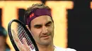 Petenis Swiss, Roger Federer merayakan kemenangannya atas Tennys Sandgren dari Amerika Serikat pada babak perempat final tunggal putra Australia Terbuka di Melbourne, Selasa (28/1/2020). Federer melaju ke semifinal usai mengalahkan Sandgren. (Manan VATSYAYANA/AFP)