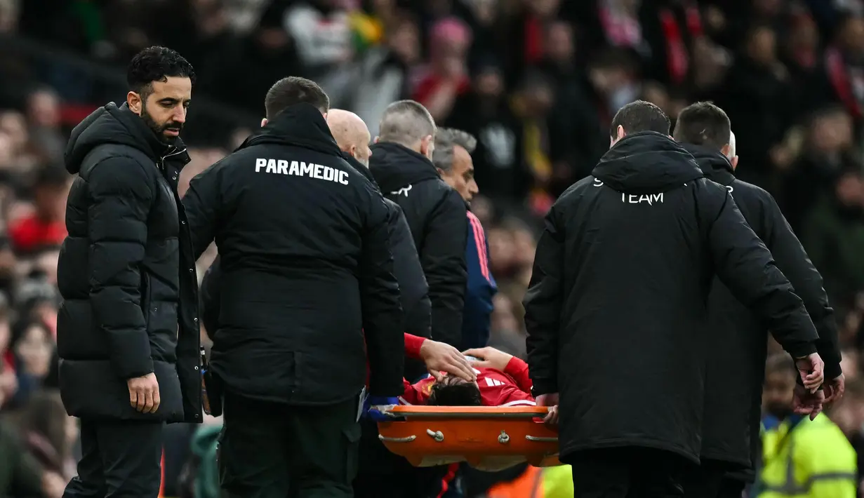 Pemain Manchester United, Lisandro Martinez ditandu keluar lapangan setelah cedera dalam laga lanjutan Liga Inggris 2024/2025 melawan Crystal Palace di Old Trafford, Manchester, Inggris, Minggu (02/02/2025). (AFP/Paul Ellis)