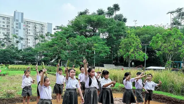 Anak-anak yang belajar menanam padi di Scientia Square Park