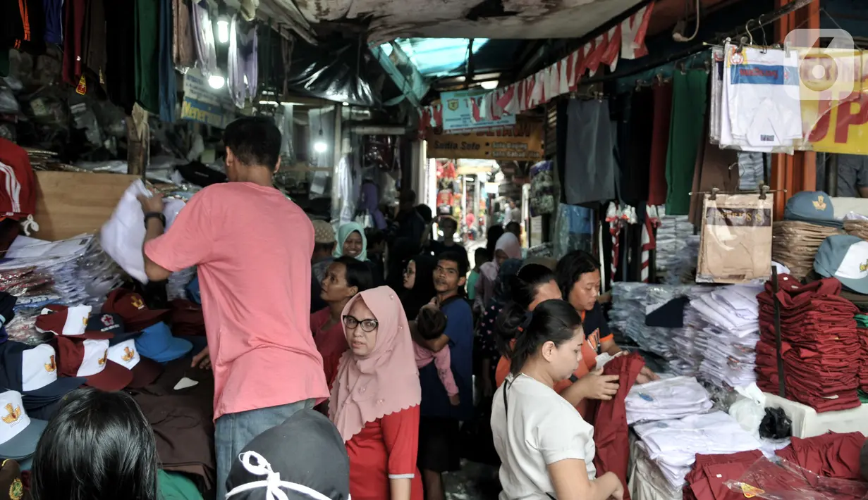 Warga berbelanja kebutuhan sekolah di Pasar Jatinegara, Jakarta, Minggu (5/1/2020). Jelang hari pertama belajar di semester baru, warga terdampak banjir di Kampung Melayu dan sekitarnya terpaksa membeli seragam baru untuk anaknya akibat banjir yang merendam rumah mereka. (merdeka.com/Iqbal Nugroho)