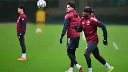 Di sisi lain, Kairat Almaty masih berupaya keras mencari poin perdana di kompetisi elite Eropa. Tampak dalam foto, gelandang Arsenal asal Inggris, Declan Rice (tengah) bersama Noni Madueke (kanan) mengikuti sesi latihan tim di pusat pelatihan Arsenal di London Colney, utara London, pada Selasa 27 Januari 2026. (Ben STANSALL/AFP)