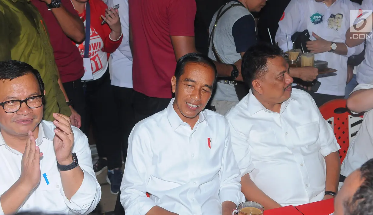 Capres nomor urut 01 Joko Widodo atau Jokowi, Politikus PDIP Pramono Anung dan Gubernur Sulut Olly Dondokambey saat ngopi di Jalan Roda, Manado, Minggu (31/3). Selain menikmati kopi Jokowi juga mendengar aspirasi dari masyarakat. (Liputan6.com/Angga Yuniar)