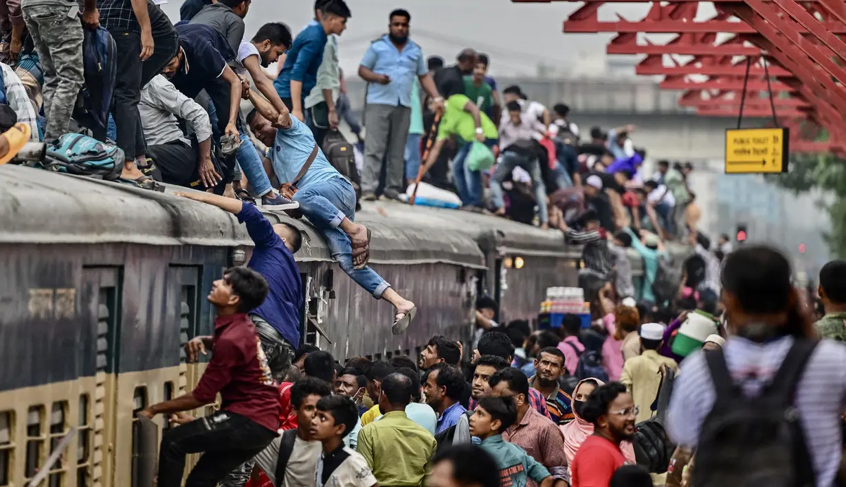 Orang-orang menaiki kereta api di stasiun kereta Tongi saat mereka dalam perjalanan pulang menjelang Idul Adha, di Tongi di pinggiran Dhaka, Bangladesh, Jumat (14/6/2024). (MUNIR UZ ZAMAN / AFP)